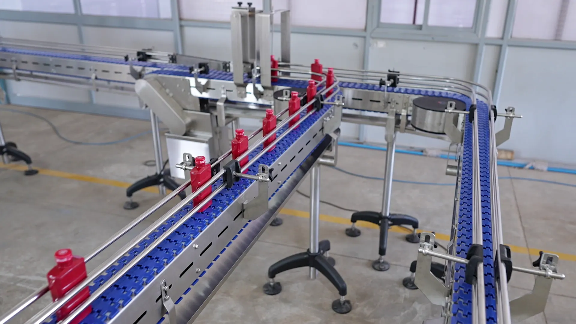 An installed modular belt line in service, bottles held in guide rails through the curves